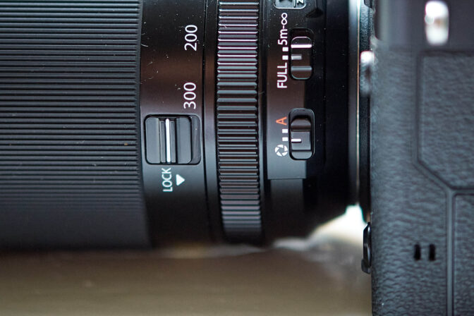 The lens features a zoom lock, focus limiter and aperture switch.